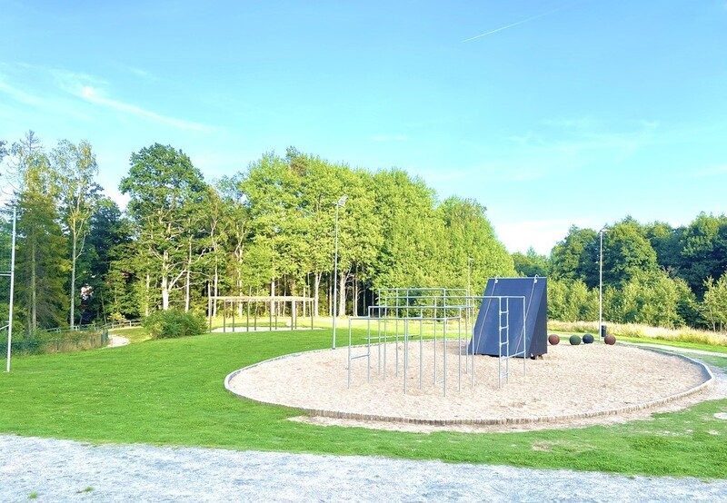 Grusad yta med utegym och klätterställning på en skolgård.